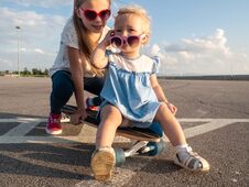 Street Sports: Two Dvoichki In Sunglasses Sit On One Large Longboard In Bright Sunny Weather. Close-up. Royalty Free Stock Photo