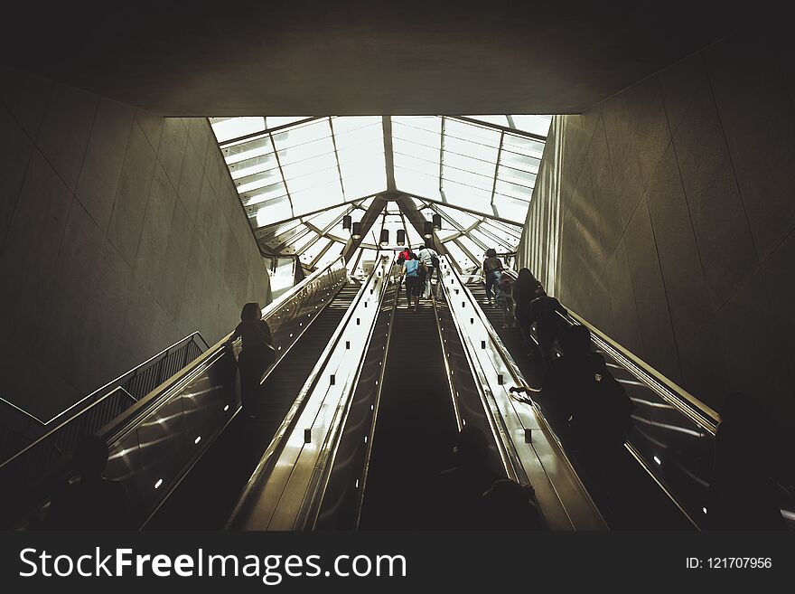 Silhouettes of people coming from the escalator.