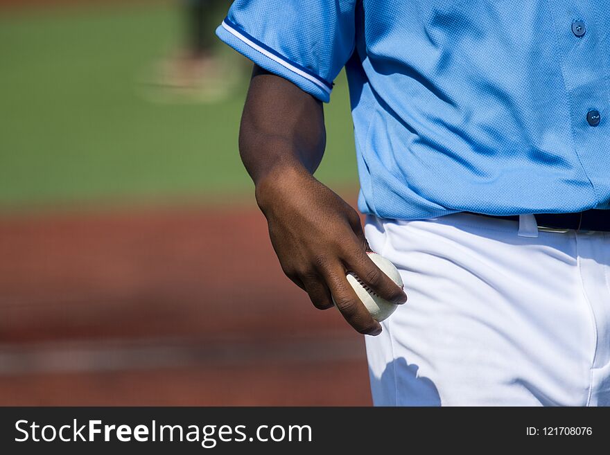 Baseball pitcher holding baseball about to throw the ball .