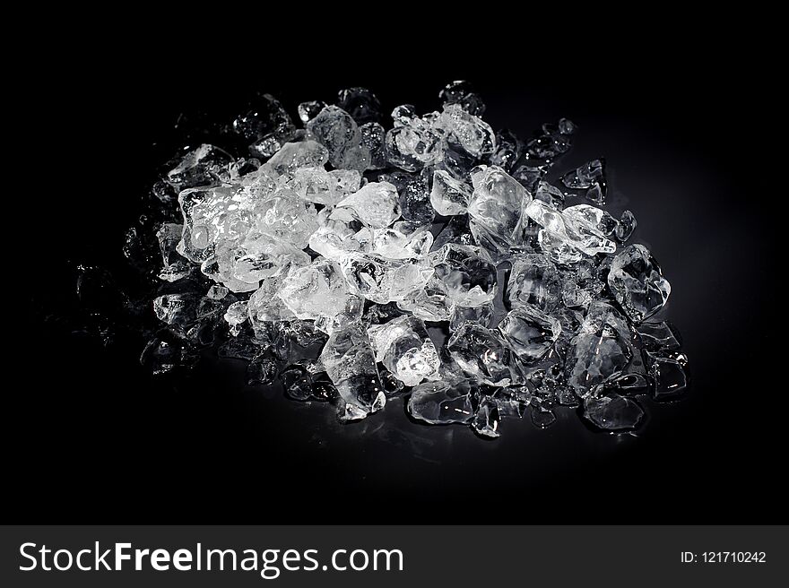 Heap of a small white and transparent ice cubes isolated on the black background starts melt. Heap of a small white and transparent ice cubes isolated on the black background starts melt