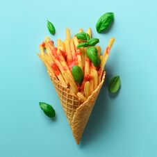 Fried Potatoes In Waffle Cones On Blue Background. Hot Salty French Fries With Tomato Sauce, Basil Leaves. Fast Food Royalty Free Stock Photo
