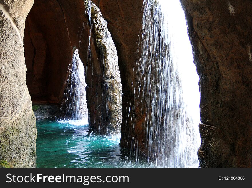 Light shining through cascading waterfalls