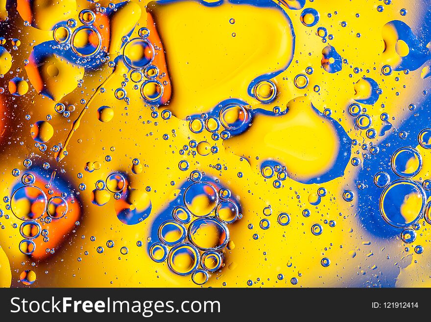 Macro shot of oil bubbles with water on colorful background. Space and universe planets styled abstract image