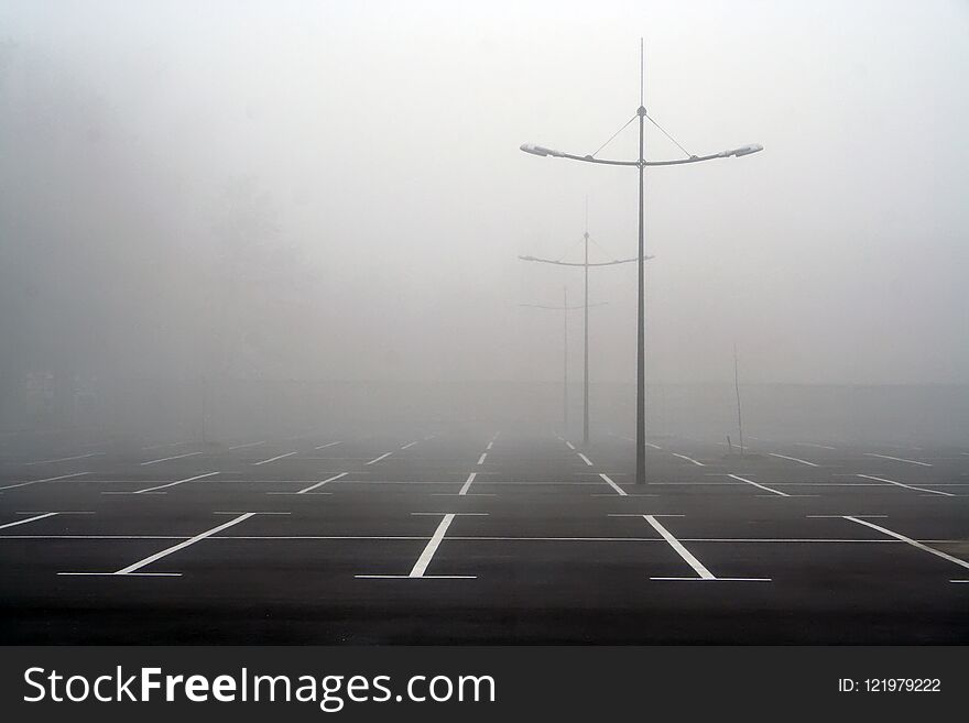 Fog on the empty parking lot. Photo in black and white colors