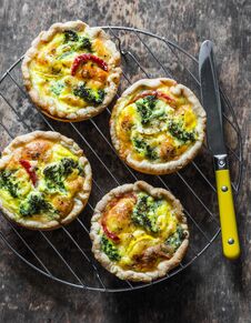 Broccoli Cheddar Mini Savory Pies On Wooden Background, Top View. Delicious Appetizers, Snack, Tapas. Flat Lay Royalty Free Stock Photo