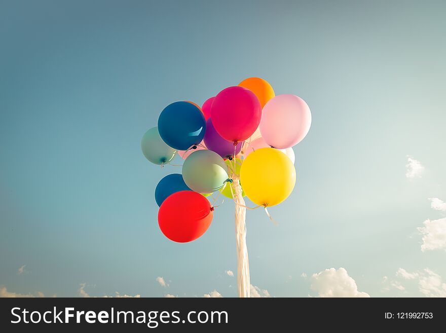 Colorful festive balloons over blue sky with a retro vintage instagram filter effect.