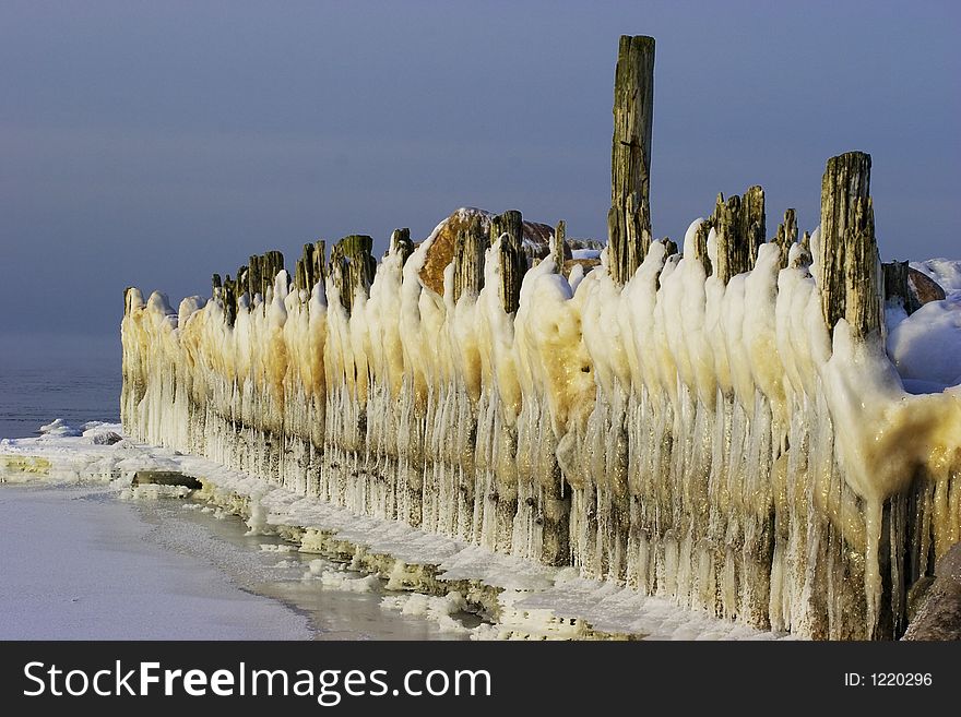 Ice-covered breakwater and icicles like line of white bearded gnomes