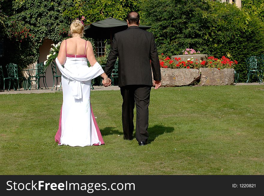 Bride and groom walking in gardens. Bride and groom walking in gardens