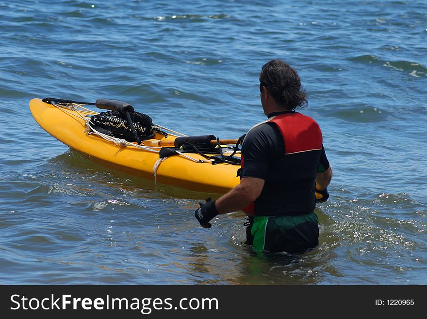 A man is ready to jump into the kayaki. A man is ready to jump into the kayaki