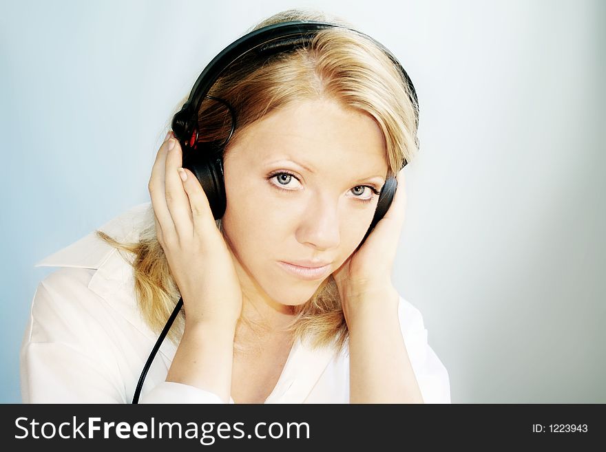 A young, blond woman is listening music