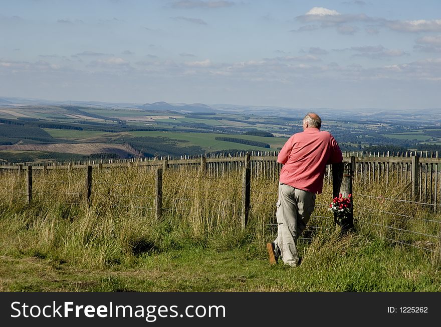 Middle aged man standing in England looking into Scotland. Middle aged man standing in England looking into Scotland