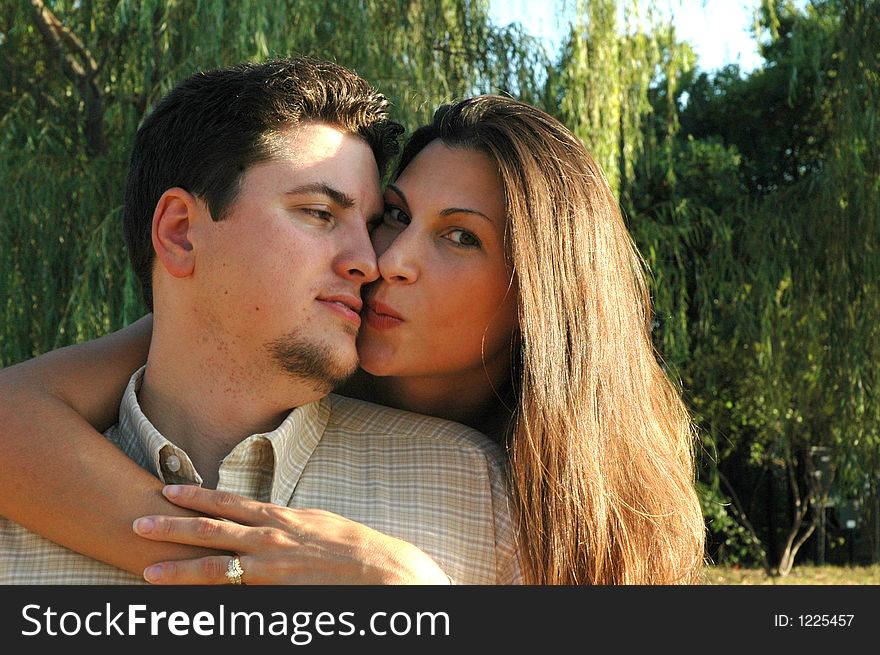 Woman leans in to give her man a kiss. Woman leans in to give her man a kiss.