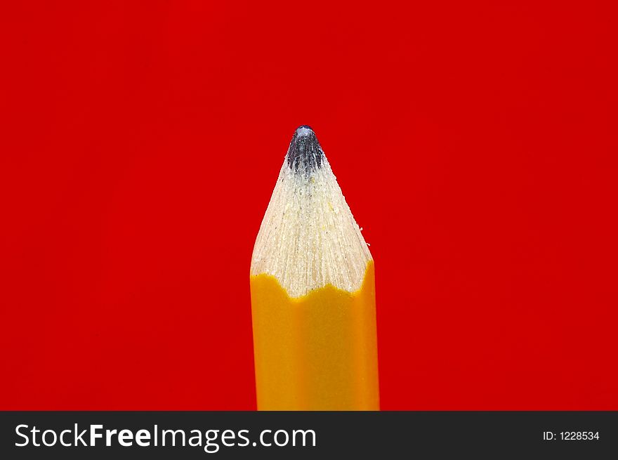 Closeup of a wooden pencil tip against a bright red background. Closeup of a wooden pencil tip against a bright red background