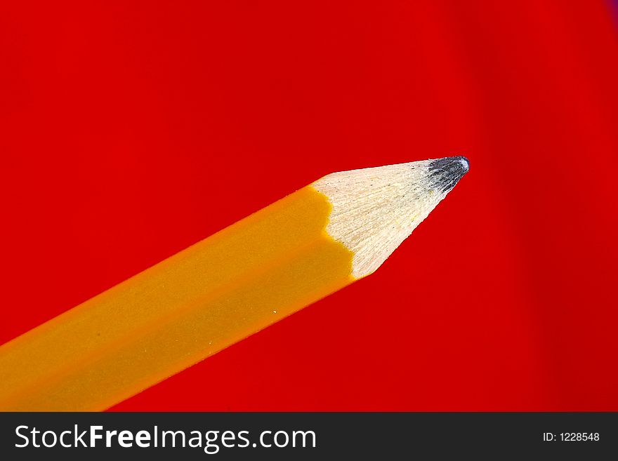 Closeup of a wooden pencil tip against a bright red background. Closeup of a wooden pencil tip against a bright red background