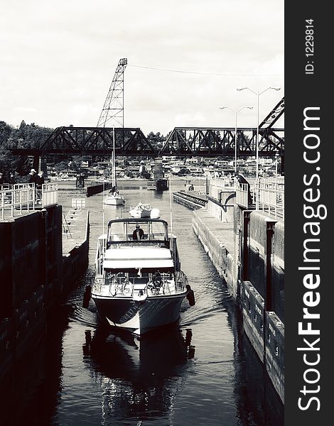 Black and white view of cabin cruiser boat in dock with industrial crane in background. Black and white view of cabin cruiser boat in dock with industrial crane in background.