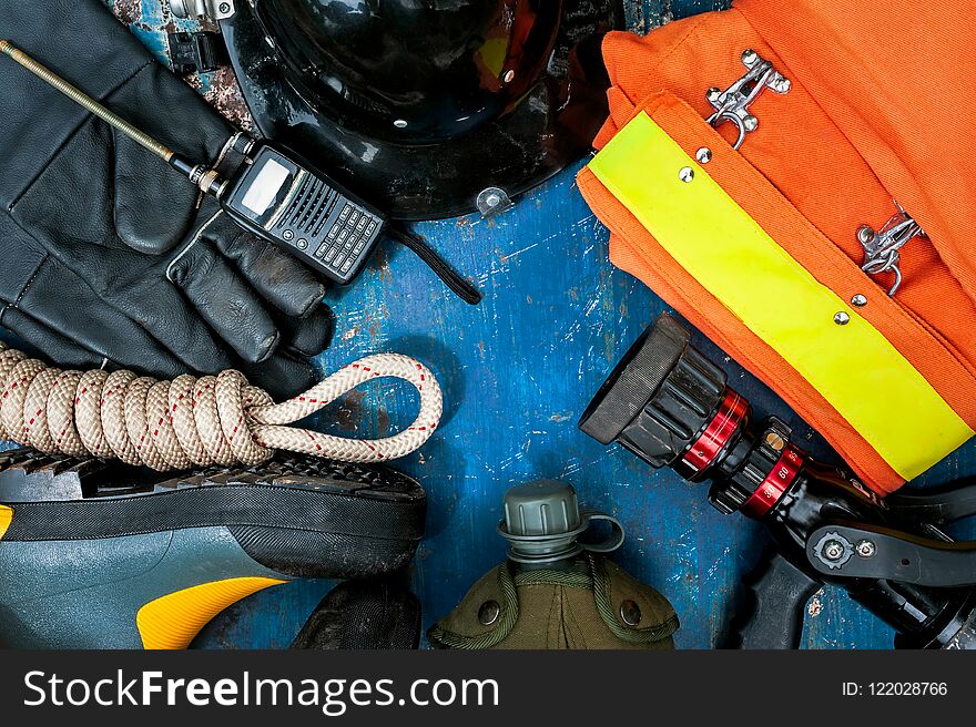 Outfit of Firefighter placed on old table background.