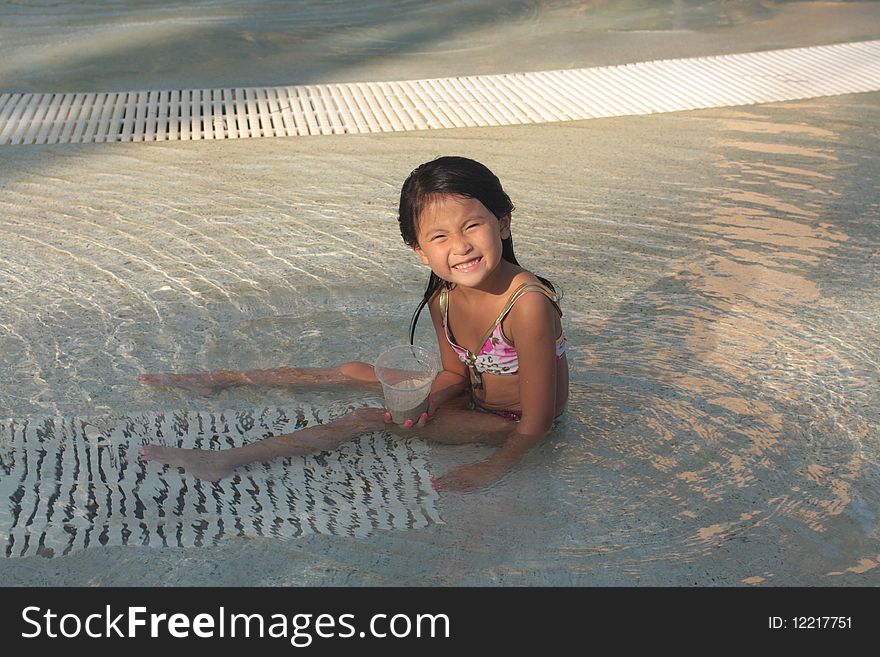 Little asian chinese girl sitting in a pool. Little asian chinese girl sitting in a pool