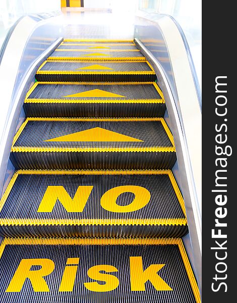 Yellow No risk sign on escalator