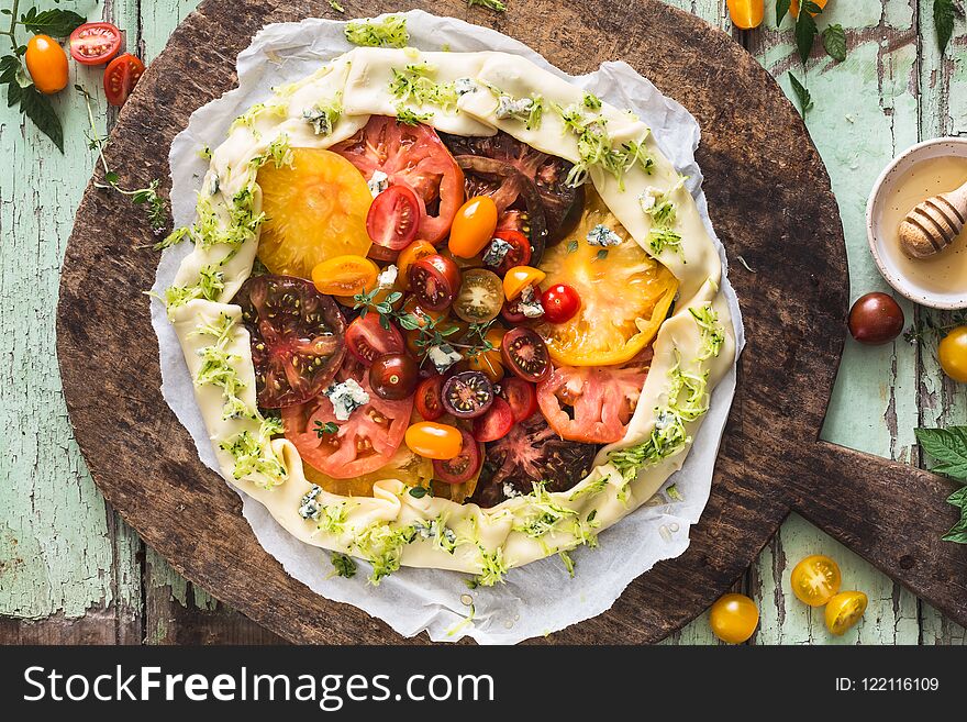 Heirloom Tomatoes Tart with Zucchini, Blue Cheese, Thyme and Honey on Wood Background