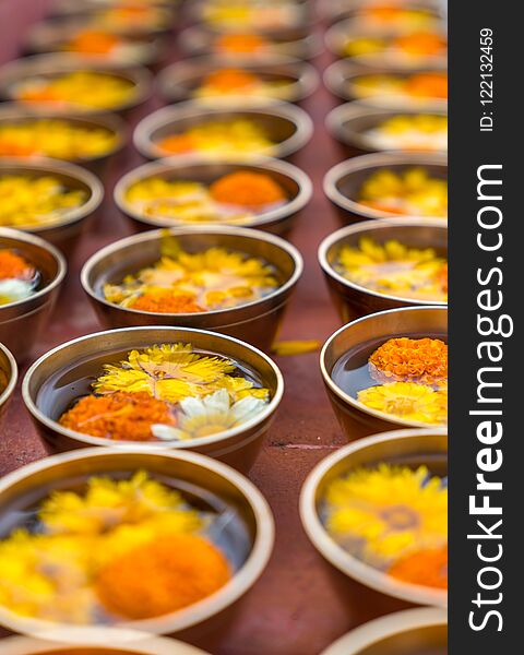Buddhist flower offerings or gifts in bowls and rows. Buddhism religion offering in a temple