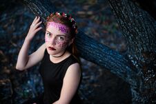 A Young Beautiful Woman With A Violet Shine On Her Face Stands Near A Burnt Tree Royalty Free Stock Photography