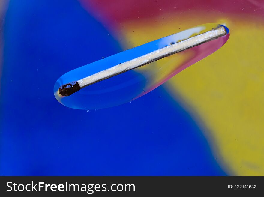 Match in a colorful background of water and oil drops