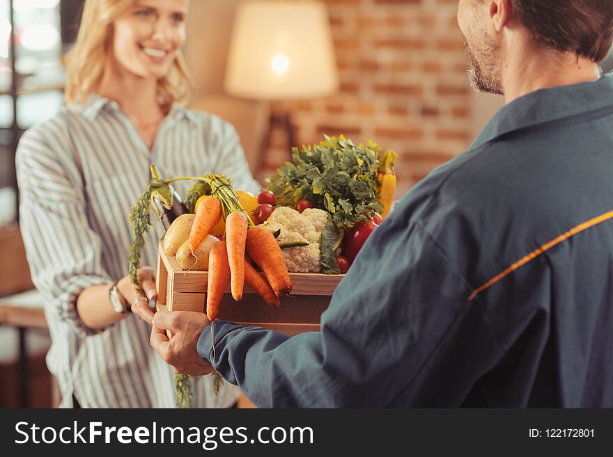 Focused photo on deliveryman that holding products