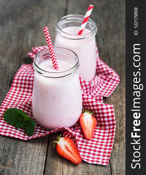 Jars with strawberry yogurt on a old wooden table