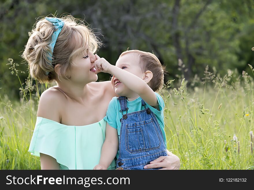 Mom and son in the park in the summer with lollipops and soap bubbles