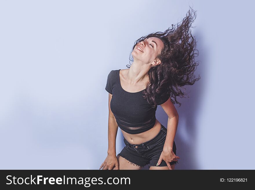 Young woman with curly hair on blue background