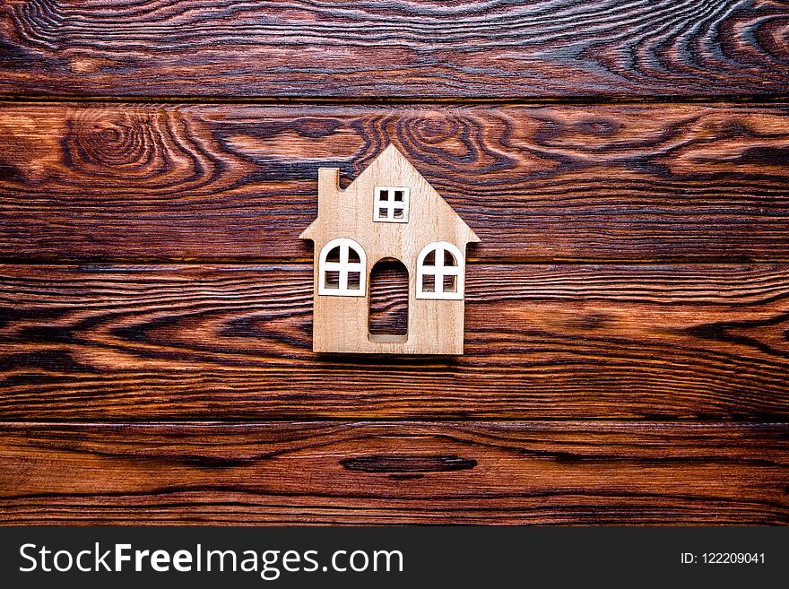 The symbol of the house stands on a brown wooden background