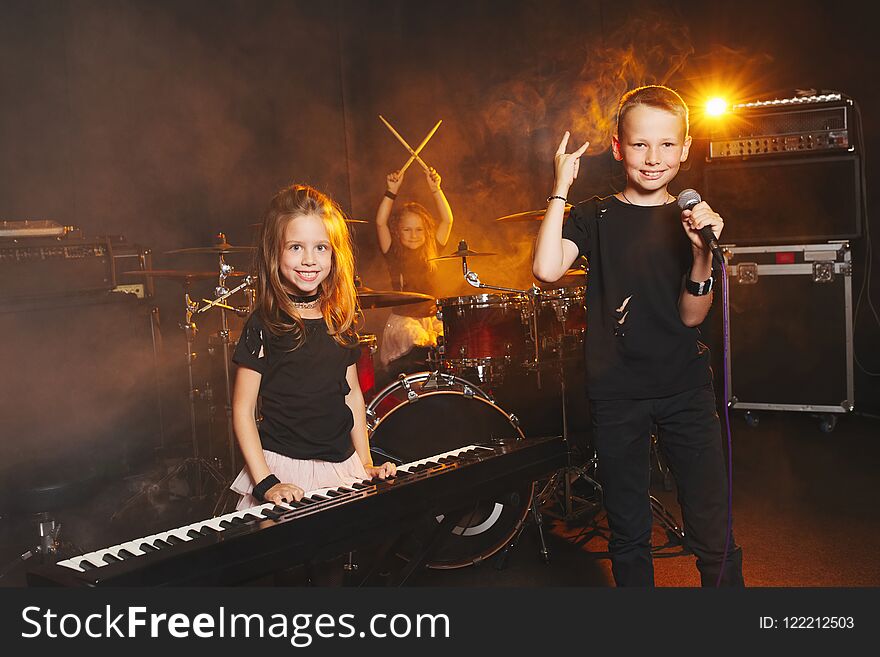 Happy children singing and playing music in studio