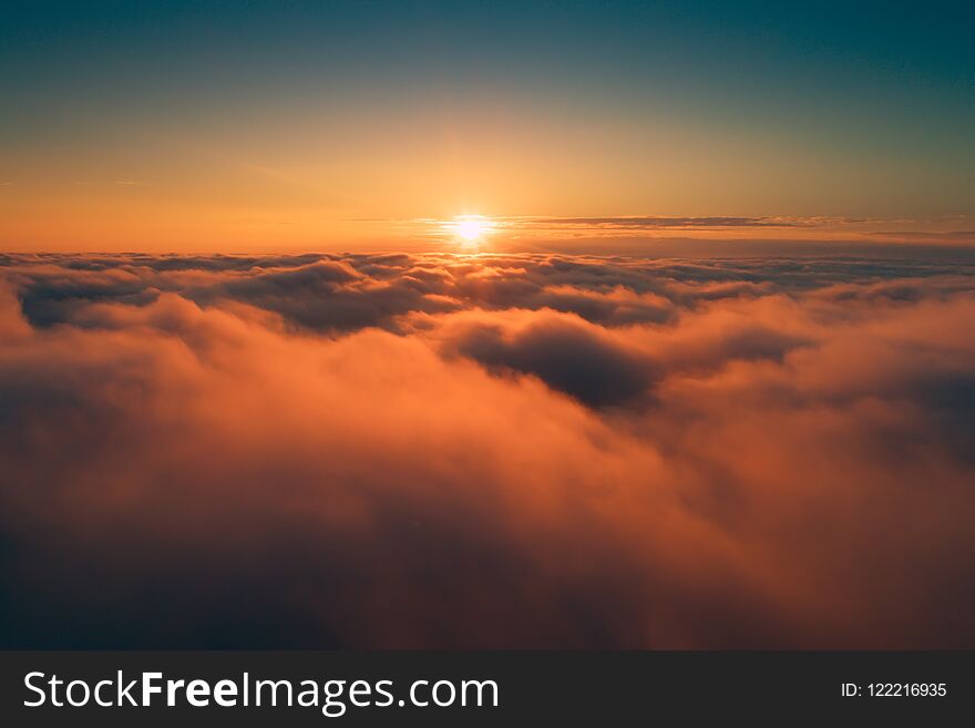 Orange clouds in the morning. Sun above clouds on clear sky background. Sunny cloudscape backdrop.