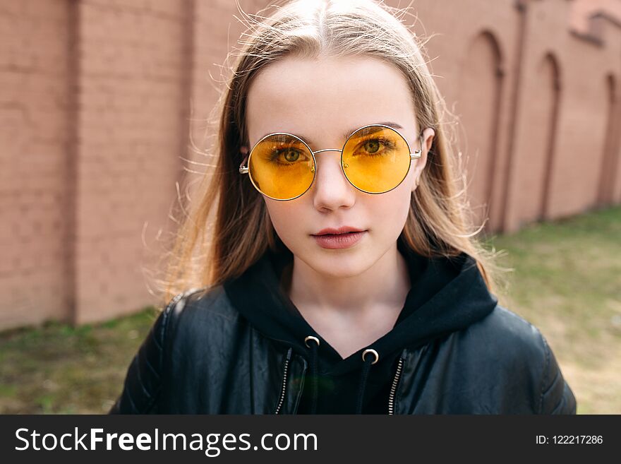 Beautiful Fashionable Kid Girl In Yellow Sunglasses In City Street