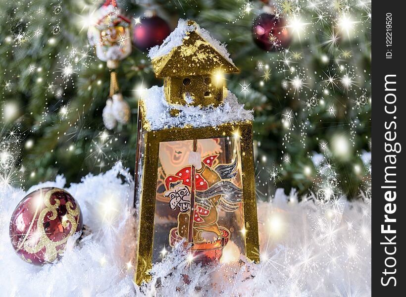 New Year`s, Christmas still life. Christmas handmade decorated lantern with a picture of fairy-tale Baba Yaga on the glass. Fir-tree background with lights. Horizontal