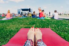 Female Feet With Red Nails On A Pink Yoga Mat On The Grass , A L Royalty Free Stock Photo