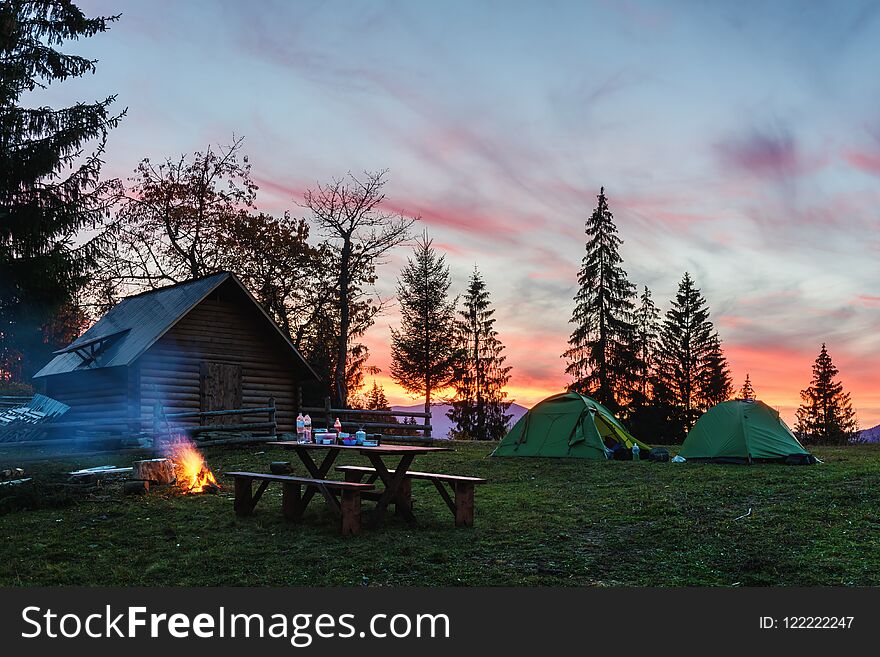 Three tents lighted from the inside by a flashlight against the backdrop of an incredible sunset sky. Amazing evening landscape. Tourism concept