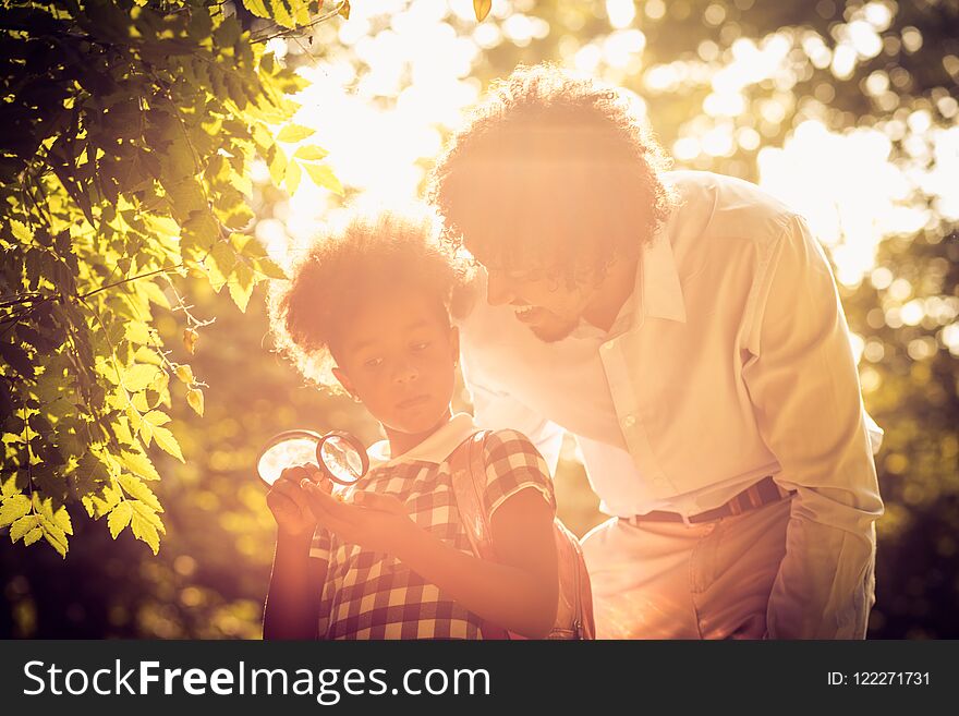 African American father and daughter researching in nature. African American father and daughter researching in nature.