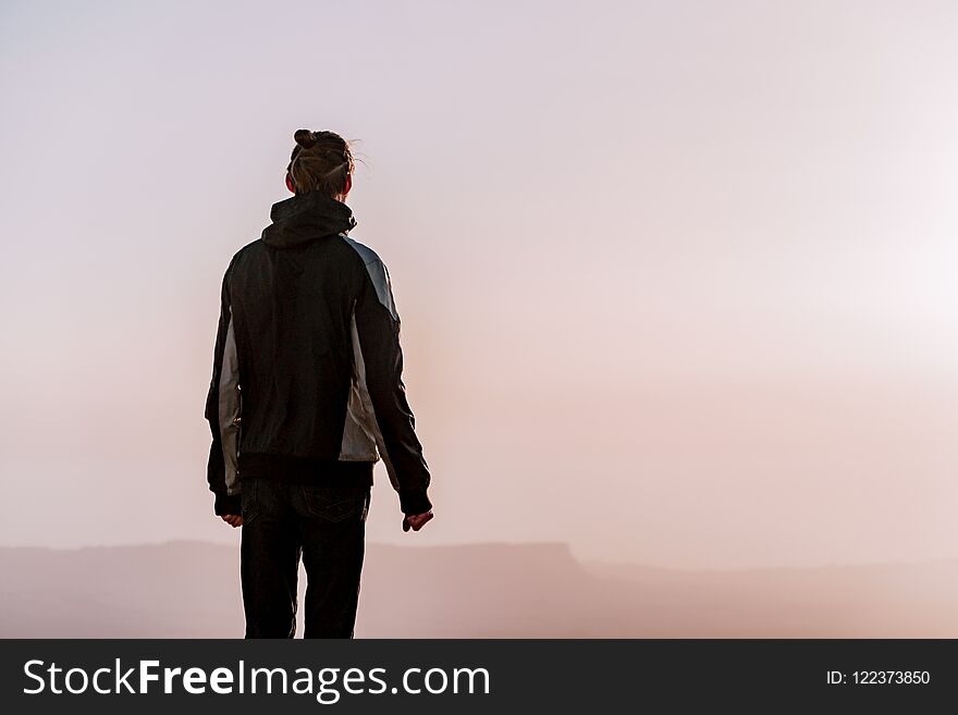 Alone Man In Israel Negev Desert Admires The View Of Sunrise. Young Male Person Stands On The Edge Of The Cliff