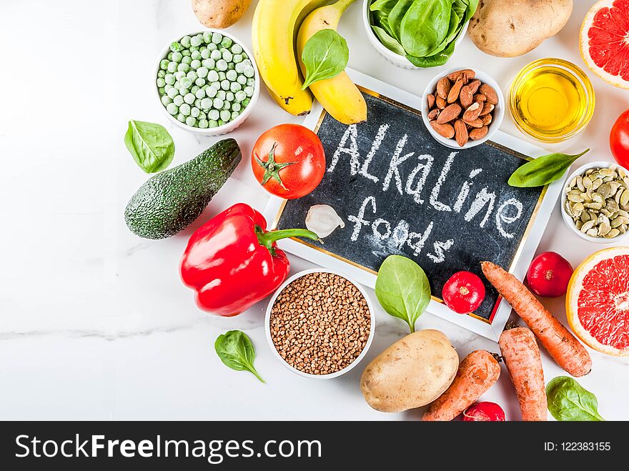Healthy food background, trendy Alkaline diet products - fruits, vegetables, cereals, nuts. oils, white marble background top view copy space. Healthy food background, trendy Alkaline diet products - fruits, vegetables, cereals, nuts. oils, white marble background top view copy space