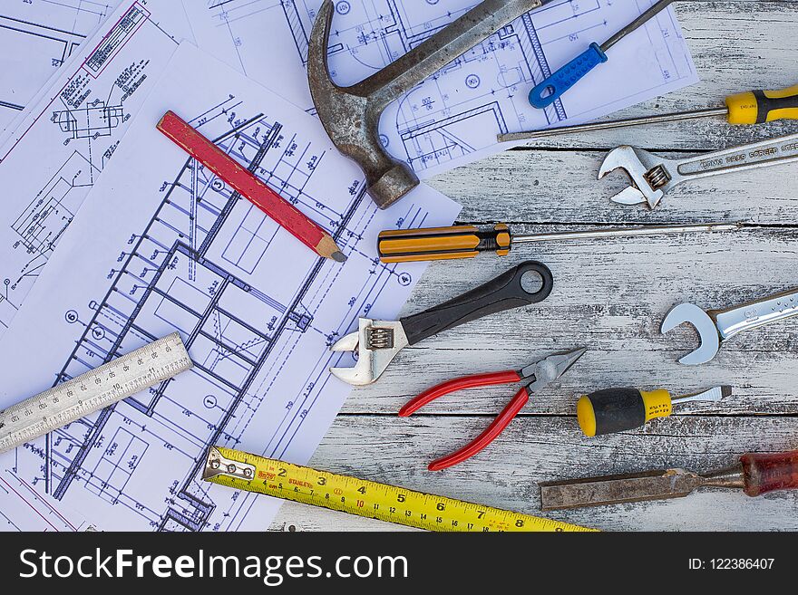 Set Of Construction Tools And Blueprints On The White,rustic Wooden Background