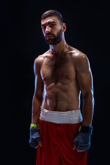 Boxing Man Ready To Fight. Boxer With Strong Hands And Clenched Fists In Blue Straps Against A Black Background Stock Photos