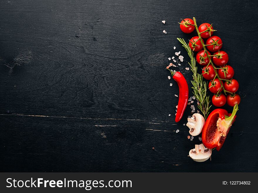 Preparation for cooking. Cherry tomatoes. Fresh vegetables and spices on a wooden background. Top view