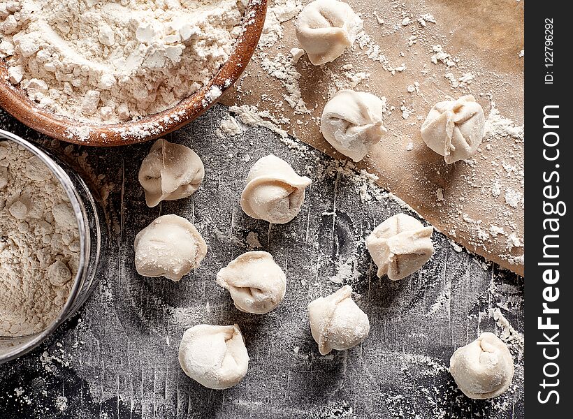 Top view flat lay raw russian dumplings with flour on table. Cooking background