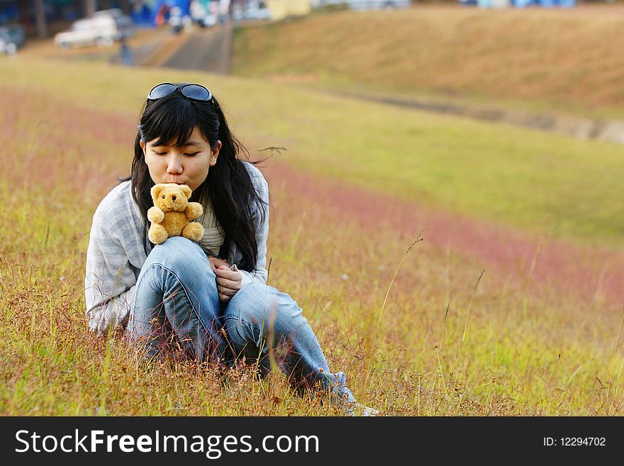 A girl sits in a grassy field. A girl sits in a grassy field.