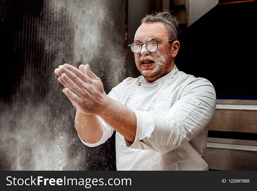 The chef throws flour and cocoa in the kitchen while cooking