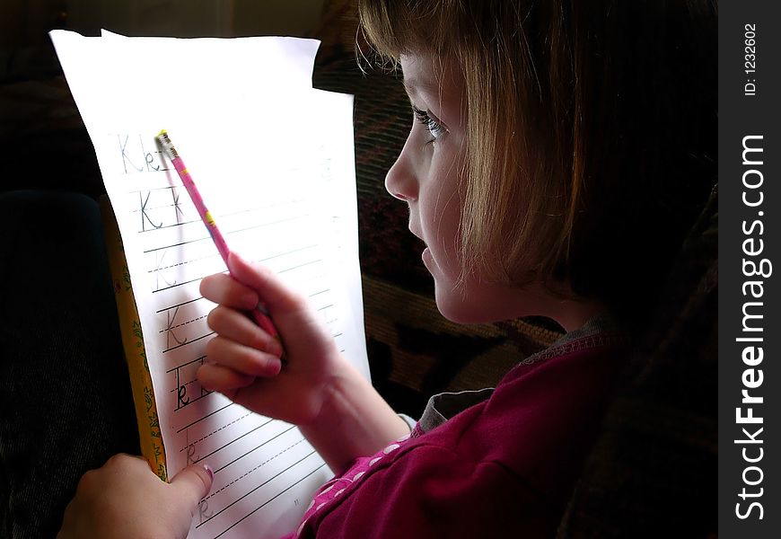 Little Girl Doing Homework with Pencil and Paper