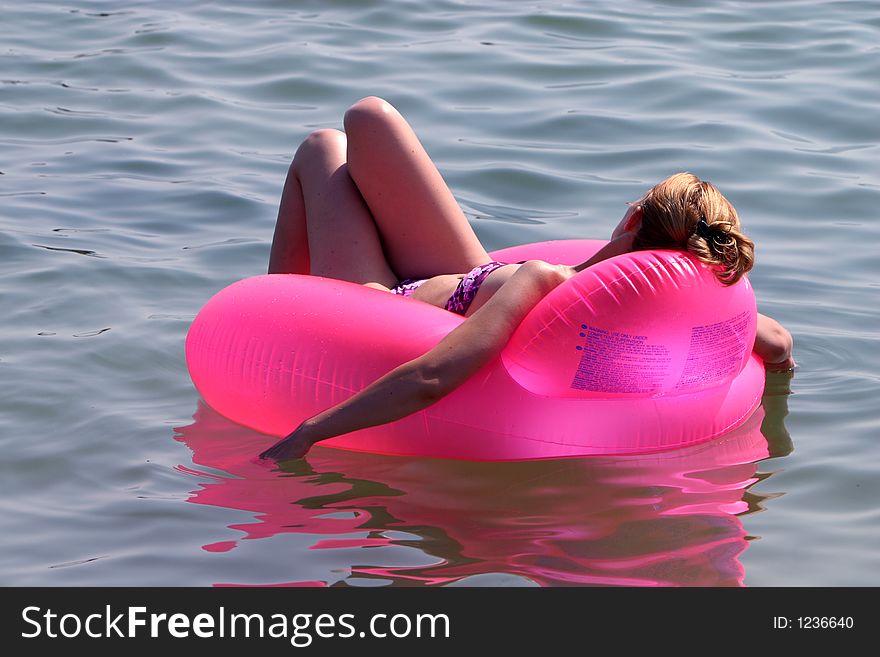 Women relaxing on a pink raft