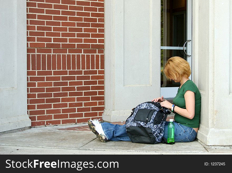 Teen girl sitting on porch with bag. Teen girl sitting on porch with bag