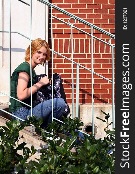 Teen sitting on steps with bag. Teen sitting on steps with bag